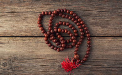 brown wooden prayer rosary on a wooden background from gray old planks