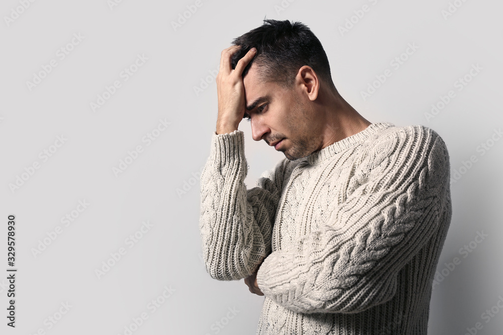 Depressed young man on light background