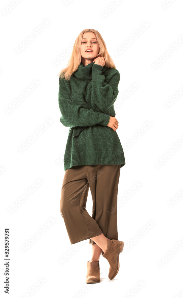 Beautiful young woman in warm sweater on white background