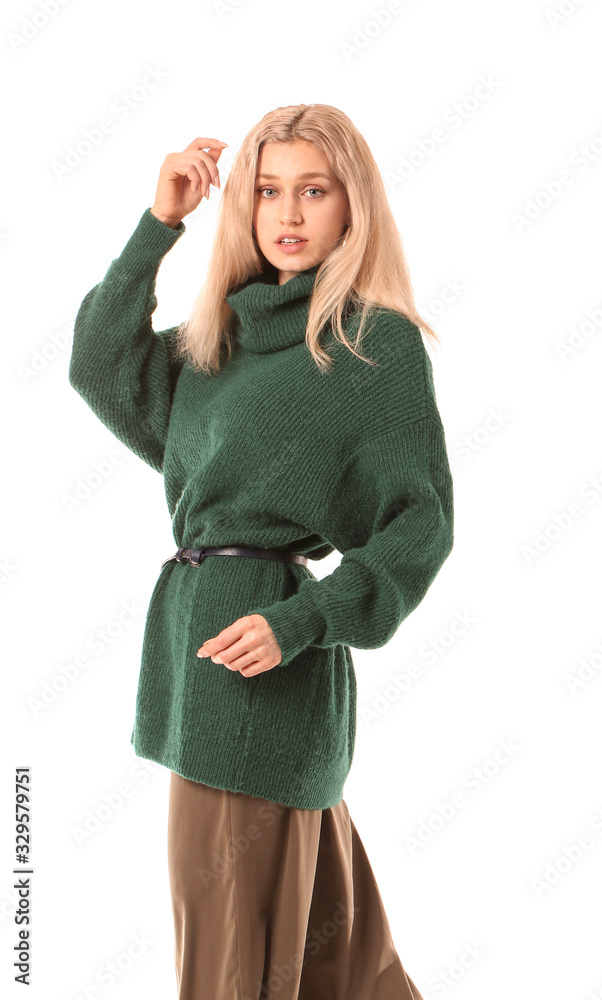 Beautiful young woman in warm sweater on white background