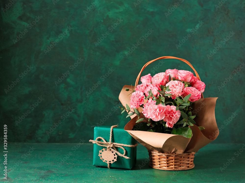 Basket with bouquet for Mother's Day and gift on table