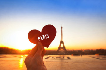 Wall Mural - Paris postcard, hand holding heart near Eiffel tower, honeymoon in France