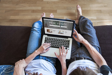 real estate concept on screen of computer, couple looking for apartment to rent or buy