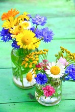 Bouquet Of Flowers In A Vase On Wooden Background