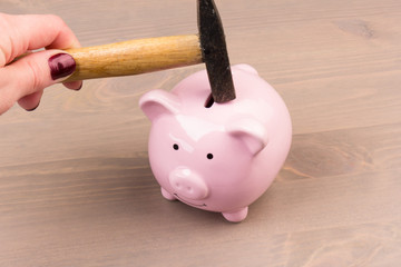 Piggy bank with  hammer on wooden background, space for text. Finance, saving money. Business to success and saving for retirement concept