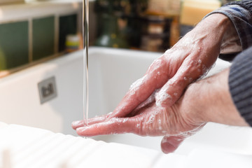  Wash hands with soap to prevent spread of germs Male hands washing in the sink