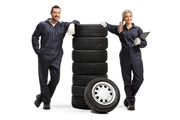 Poster - Male and female auto mechanics with a pile of tires