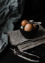 Quail And Chiken Eggs In Black Bowl On Wooden Black Background. Dark Mode. Easter Concept.