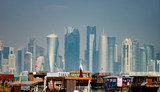 Fototapeta Las - Panoramic view of modern skyline of Doha with old fishing boats foreground