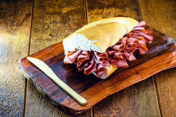 Wall Mural - bologna snack. Bread with sliced ​​pork, on rustic wooden background, typical Brazilian snack.