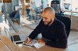 © Nana_studio - African american businessman sitting at a computer in his startup office