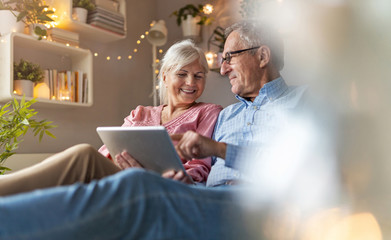 Canvas Print - Mature couple using a laptop while relaxing at home