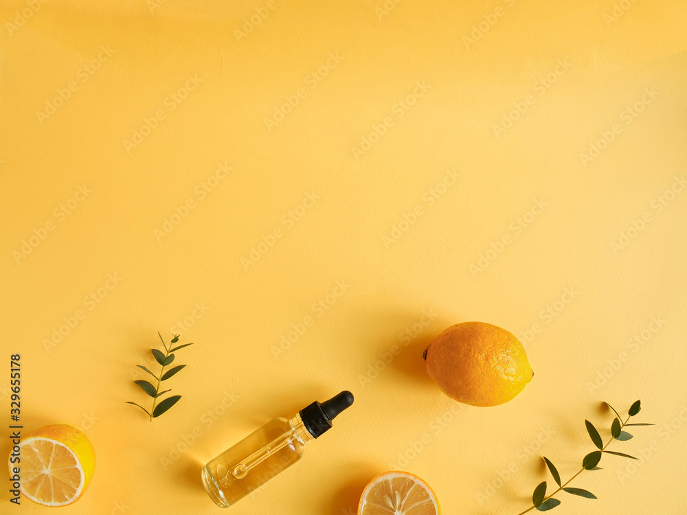 bright flatlay composition with oil, citrus and eucalyptus. on yellow background. Concept beauty natural vitamin cosmetic product, skin care, copyspace, top view - obrazy, fototapety, plakaty 