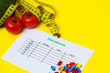 © Maksymiv Iurii - Diet plan for weight loss pills and fresh vegetables on a yellow background