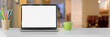 © bongkarn - Cropped shot of simple workspace with blank screen laptop, cup, stationery and copy space