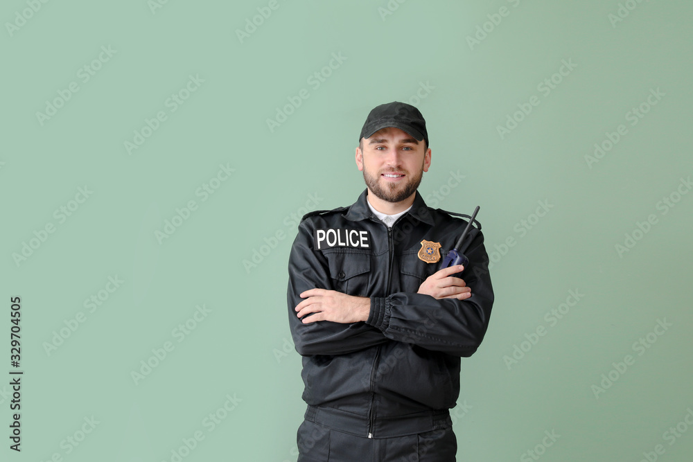 Male police officer on color background