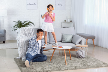 Canvas Print - Asian man drinking tea while his little daughter singing at home