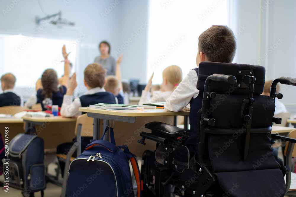 A disabled student in a wheelchair in primary school. - obrazy, fototapety, plakaty 