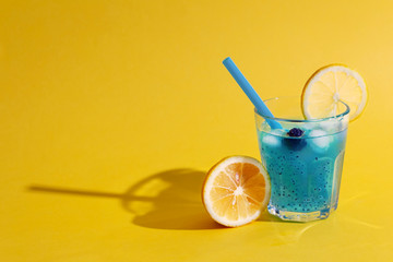 Wall Mural - Crazy blue cocktail with lime and chia seeds in glass on orange background. Summer and vacation holidays concept. Copy space.