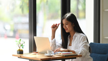 Photo Of Executive Woman Working With Computer Laptop While Sitting At The Modern Wooden Table With Orderly Office As Background. Comfortable Workplace Concept.