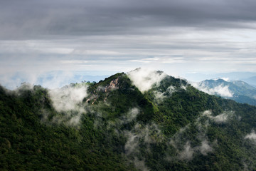 Beautiful view of clouds over the green mountain peak from Pha Tang view point in Chiang Rai, Thailand.