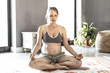 © Mangostar - Peaceful expectant mother meditating at home. Pregnant woman with closed eyes sitting in lotus pose on carpet, making zen gesture. Pregnancy and yoga concept