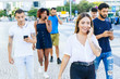 © Mangostar - Happy excited woman talking on cell while walking down city street. Mix raced men and women going outside, talking on cells, using mobile phones. Smartphone using concept
