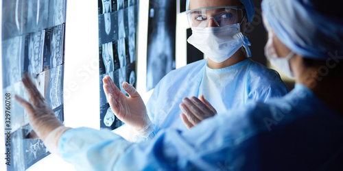 Two female women medical doctors looking at x-rays in a hospital Tableau sur Toile