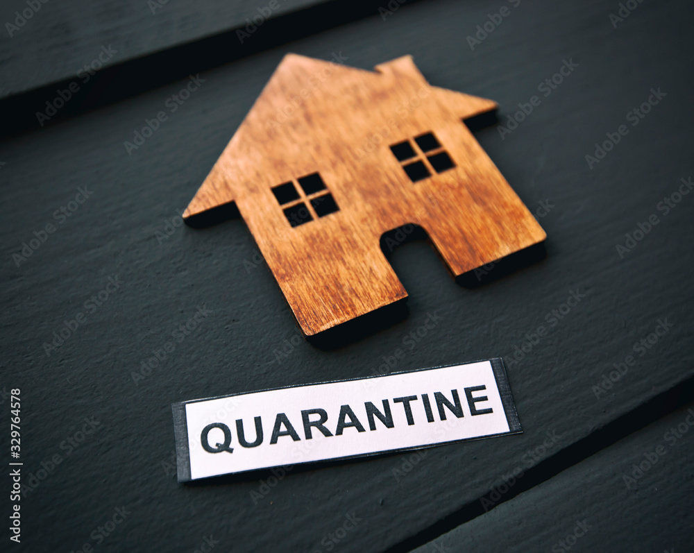 The little wooden house and banner with text "quarantine" on the table. Concept of coronavirus quarantine - obrazy, fototapety, plakaty 