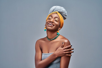 African american woman standing over isolated grey background hugging oneself happy and positive, smiling confident.