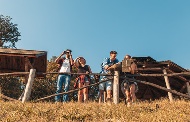 Wall Mural - Group of four friends hiking through countryside together at sunset.