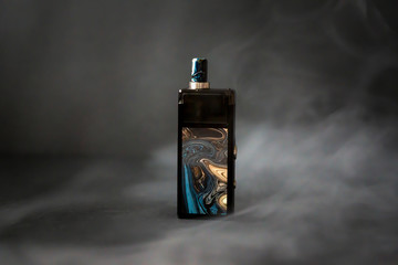 Electronic cigarette on a black background with steam and a box.