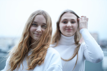 Two young woman looking at camera outdoors. Portrait of teenage girls