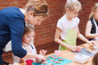 © Przemek Klos - Little girl with her mom's help decorating baked cookies with colorful sprinkle and icing sugar. Kid taking part in baking workshop. Baking classes for children, aspiring little chefs