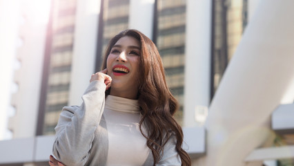 Asian business woman standing and finger up like a eureka action and feeling happy which represent have a brilliant idea, thoughtful, solve problem, imagination, inspiration or clever moment in work