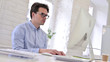 © stockbakers - Working Young Man using Laptop in Modern Office