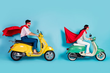 Poster - Full length photo of cool lady guy drive sit two vintage moped wear red cape mask rushing road halloween party play super heroes role coat flying air isolated blue color background