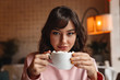 © Drobot Dean - Woman indoors in cafe drinking coffee.