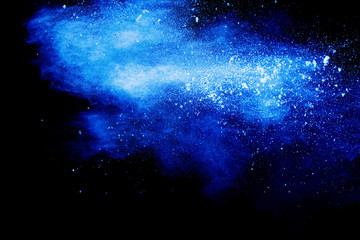 Wall Mural - Blue color dust particles explosion cloud on black background.Color powder splash.