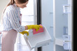 © New Africa - Woman in rubber gloves cleaning refrigerator, closeup