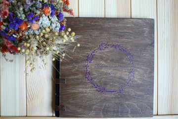 Wall Mural - album photo book with  the inscription in a brown wooden cover with with a decor next to flowers