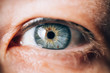 Leinwandbild Motiv blue eye with brown spots of a mature woman with wrinkles