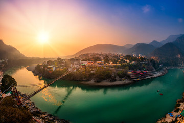 View of Ganga river embankment, Lakshman Jhula bridge and Trimbakeshwar Temple in Rishikesh, Uttarakhand, India