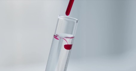 Wall Mural - scientist with pipette analyzes red colored liquid to extract the dna and molecules in the test tube