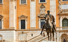 Rome Italy. Bronze Statue Of Roman Emperor Marcus Aurelius On Steed At Capitol Square Among Vintage Buildings With Ancient Architecture.