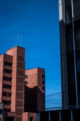 two buildings with shadows and blue sky