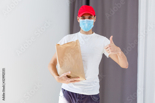 Fotomural Delivery man holding paper bag with food on white background, food delivery man