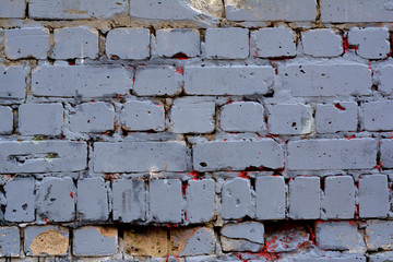 Old gray brick wall with traces of red paint for background or texture