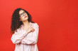 © denis_vermenko - Image of thinking young student lady standing isolated over red background. Looking aside. Pointing finger.