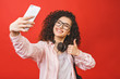 © denis_vermenko - Pretty young happy student woman with headphones making selfie on smartphone.